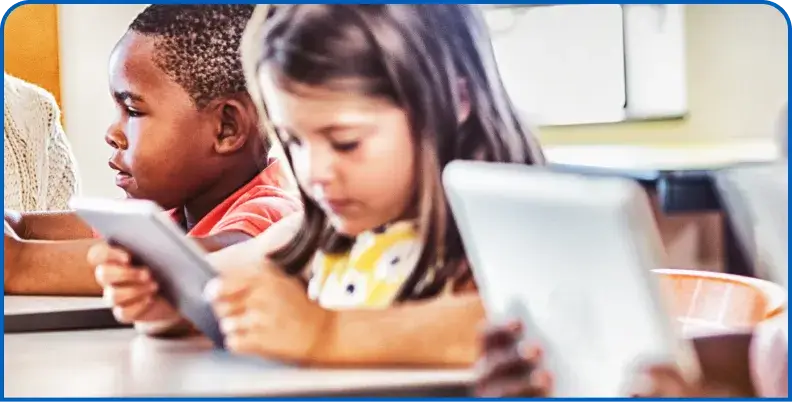 Children using tablets together in a classroom