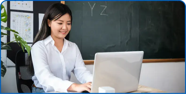 Educator using a laptop in a classroom setting