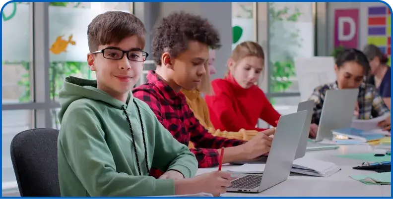 Students working on laptops together in a classroom